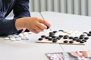 Kinder spielen das asiatische Spiel "Go"