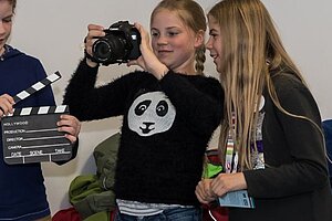 Kinder drehen einen Film mit Klappe und Kamera
