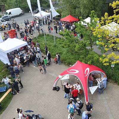 Stände und Menschen rund um die Junior Uni während des Forscherfestes im Mai 2022. 