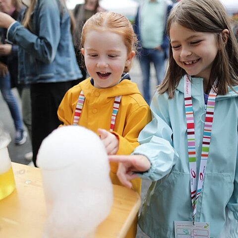 Besucherinnen freuen sich über Experimente mit Trockeneis beim Sommerfest 2022