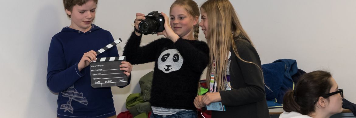 Kinder drehen einen Film mit Klappe und Kamera