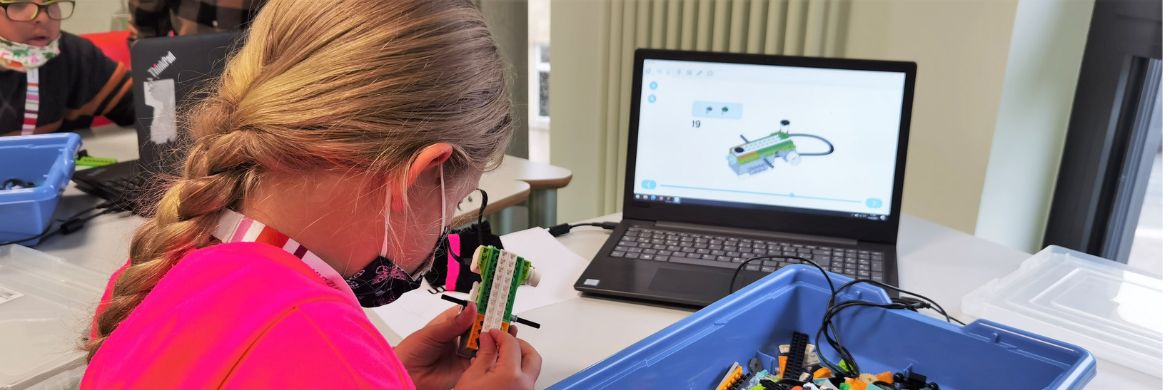 Kind programmiert Lego Roboter